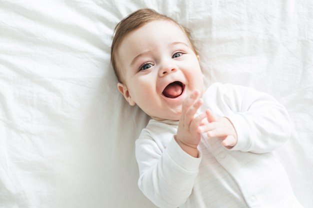 newborn-toddler-boy-laughing-bed_115594-1499